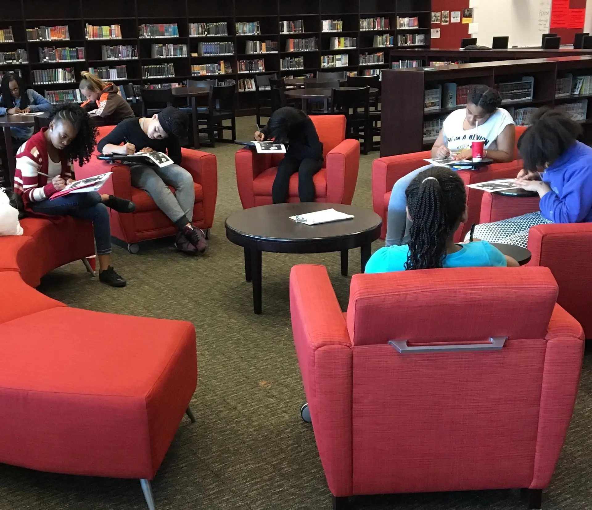Students reading and writing in workbooks during a workshop